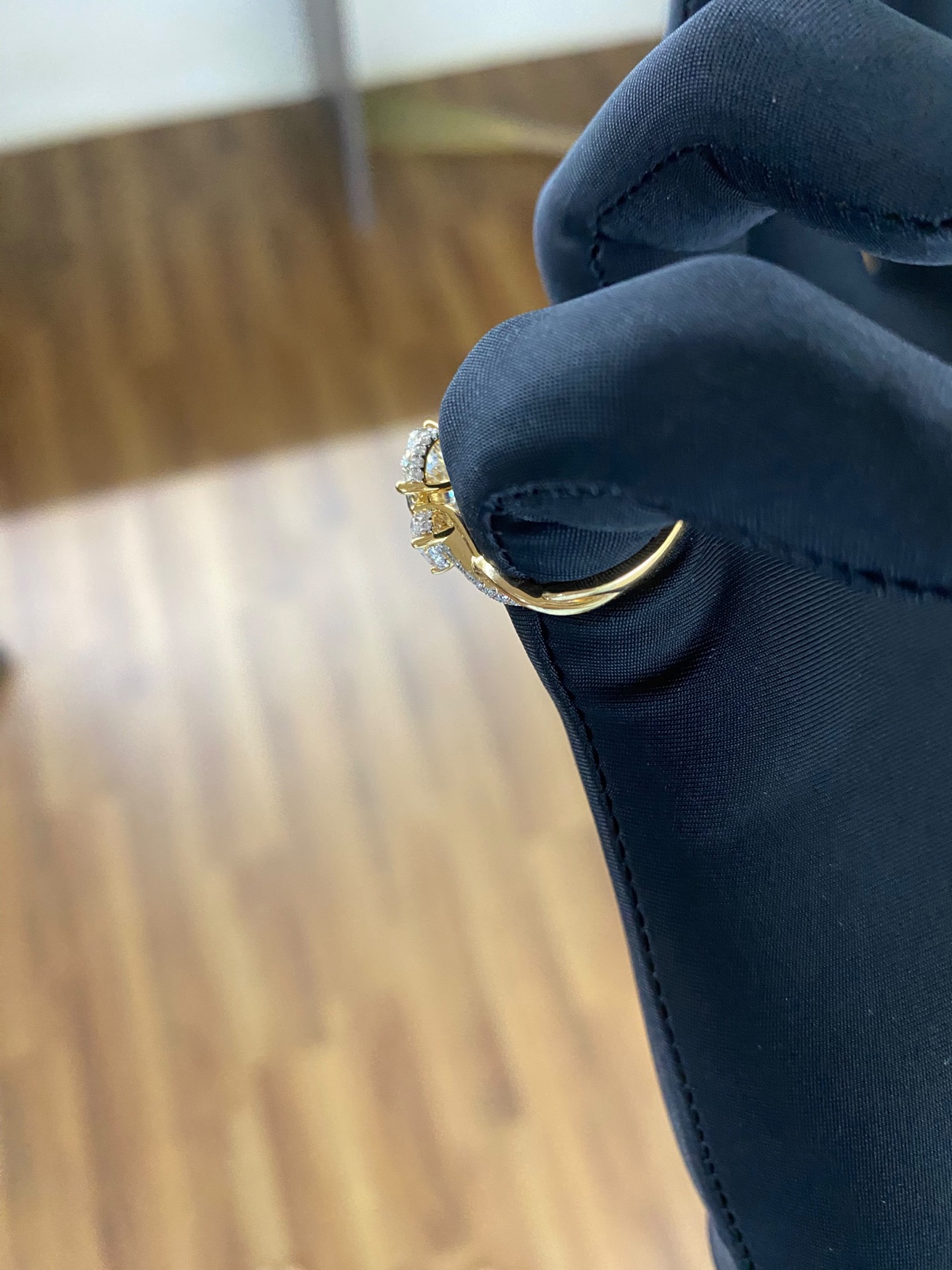 Oval three-stone engagement ring in solid 14K yellow gold, angled view